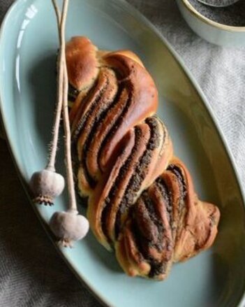 Auf dem Foto ist ein Teller mit einem Mohnzopf darauf zu sehen. Daneben steht eine kleine Schale mit Mohn darinnen. | © SONNENTOR
